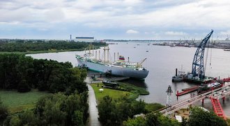 Luftaufnahme von Frachtschiff MS Dresden und Schwimmkran. Im Hintergrund Hafenanlagen von Überseehafen