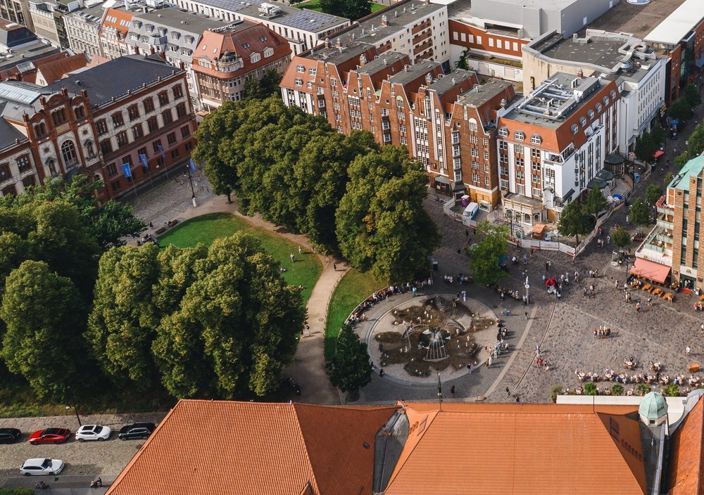 Luftaufnahme Universitätsplatz Innenstadt Rostock. Giebelhäuser im Vordergrund und Warnow im Hintergrund
