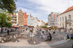 Spielende Kinder an Brunnen, in der Innenstadt von Rostock. 